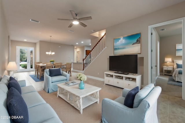 living room with ceiling fan with notable chandelier