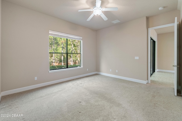 spare room featuring ceiling fan and light colored carpet