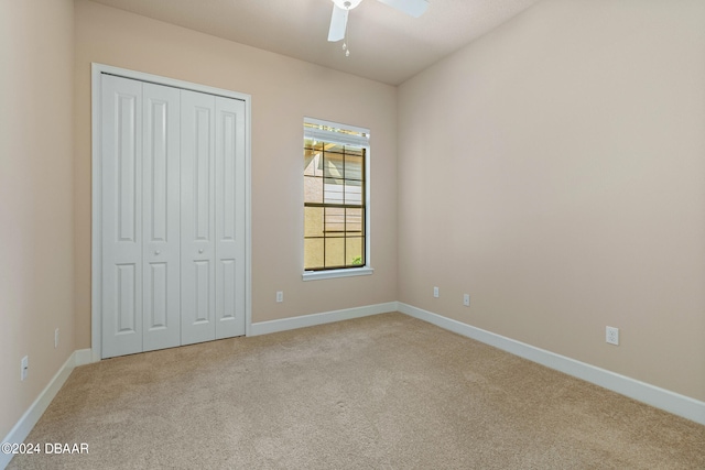 unfurnished bedroom with light carpet, ceiling fan, and a closet