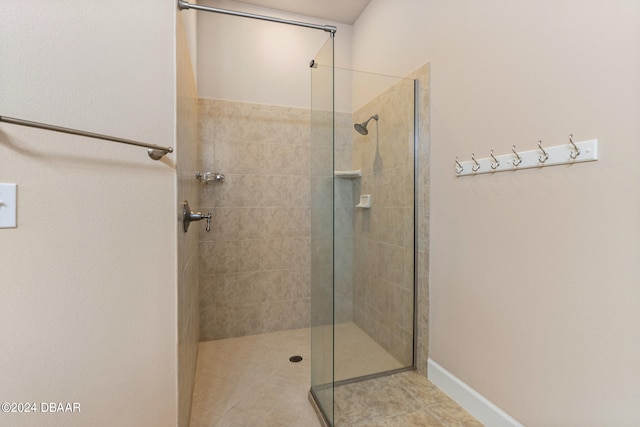 bathroom featuring tile patterned flooring and tiled shower