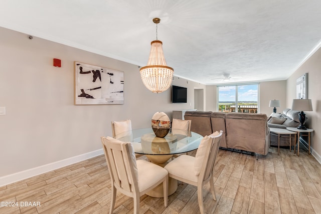 dining area featuring crown molding, light hardwood / wood-style floors, and ceiling fan with notable chandelier