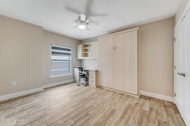 3797 S Atlantic Ave Unit 404, Daytona Beach, FL 32118 - unfurnished office featuring built in desk, a ceiling fan, light wood-style flooring, and baseboards