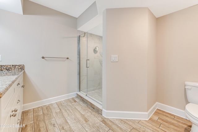 bathroom featuring wood-type flooring, vanity, toilet, and an enclosed shower