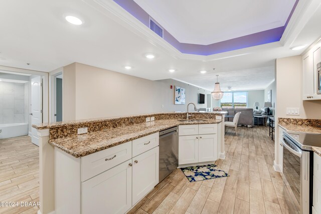 3797 S Atlantic Ave Unit 404, Daytona Beach, FL 32118 - kitchen with stainless steel appliances, light wood-style floors, open floor plan, a sink, and a raised ceiling
