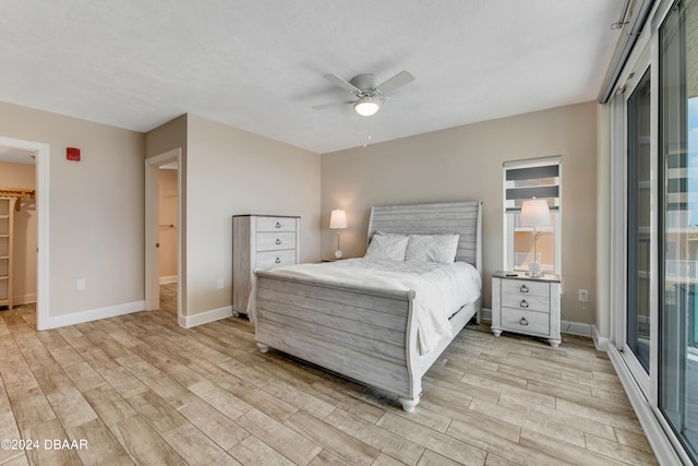 bedroom with a spacious closet, ceiling fan, light hardwood / wood-style floors, access to outside, and a closet