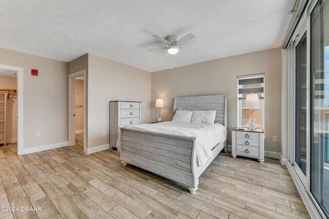 3797 S Atlantic Ave Unit 404, Daytona Beach, FL 32118 - bedroom featuring light wood-style flooring, a walk in closet, baseboards, and access to exterior