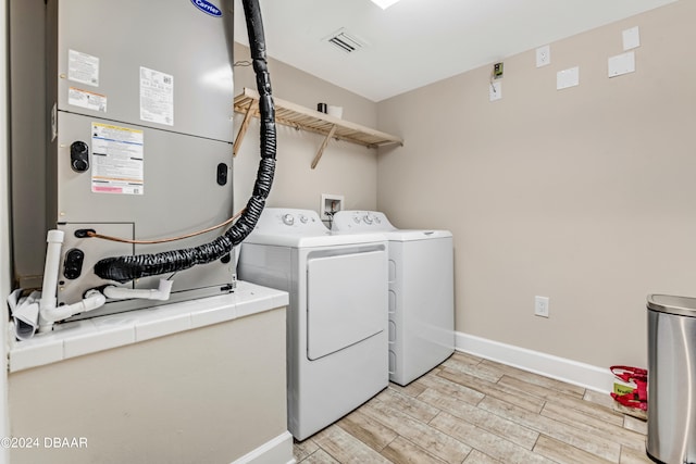 washroom with independent washer and dryer and light hardwood / wood-style flooring