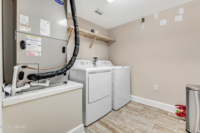 3797 S Atlantic Ave Unit 404, Daytona Beach, FL 32118 - laundry area featuring baseboards, light wood-style flooring, and washer and dryer
