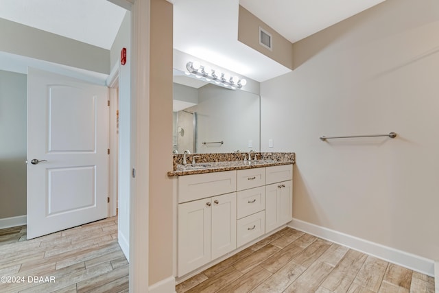 3797 S Atlantic Ave Unit 404, Daytona Beach, FL 32118 - full bathroom with double vanity, wood finished floors, and baseboards