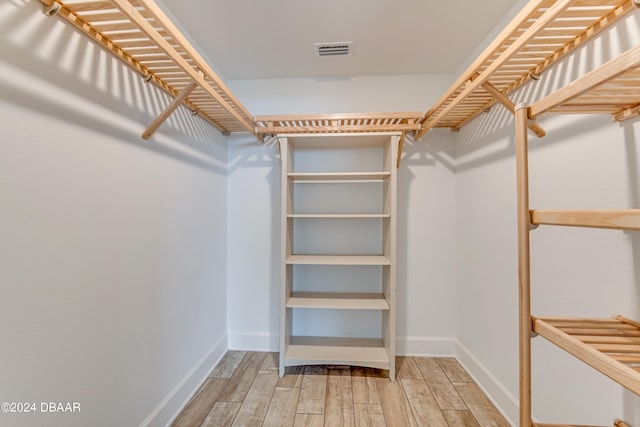 spacious closet with hardwood / wood-style flooring