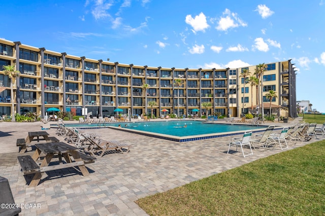 view of swimming pool featuring a patio area and a yard