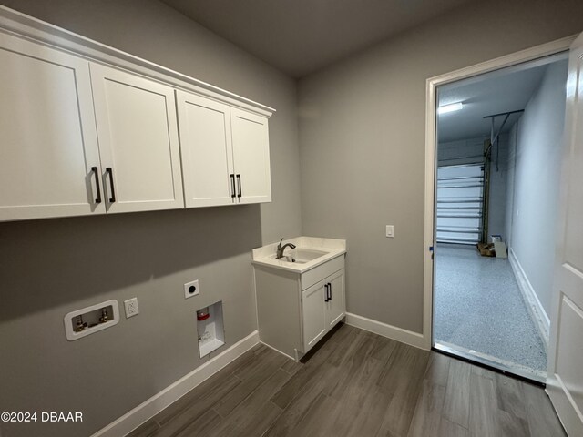 washroom featuring cabinets, hookup for a washing machine, dark wood-type flooring, electric dryer hookup, and sink