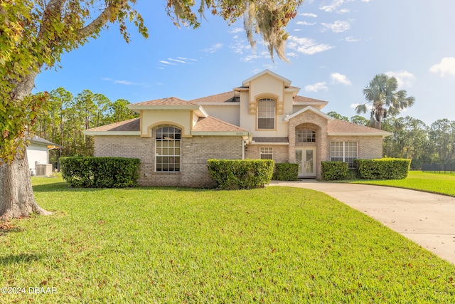 mediterranean / spanish home with a front yard and central air condition unit