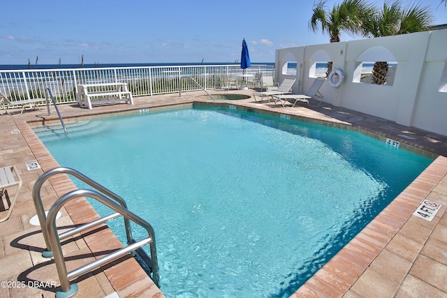 view of swimming pool featuring a patio and a water view