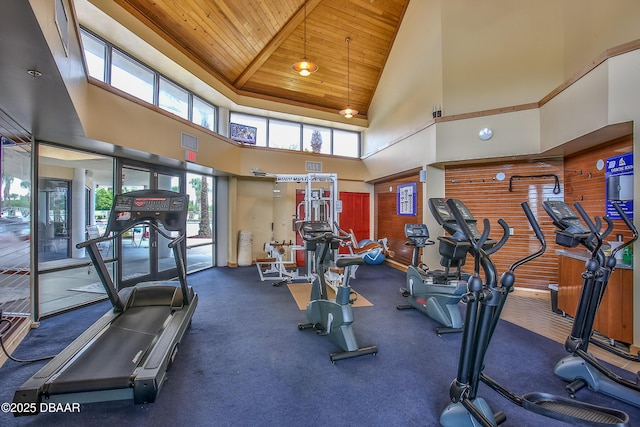 gym featuring a towering ceiling and wood ceiling