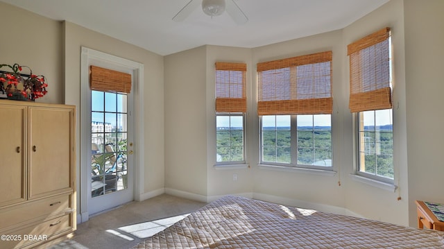 bedroom featuring light colored carpet, ceiling fan, access to exterior, and multiple windows