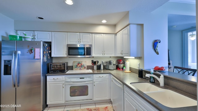 kitchen featuring stainless steel appliances, light tile patterned floors, white cabinets, and sink