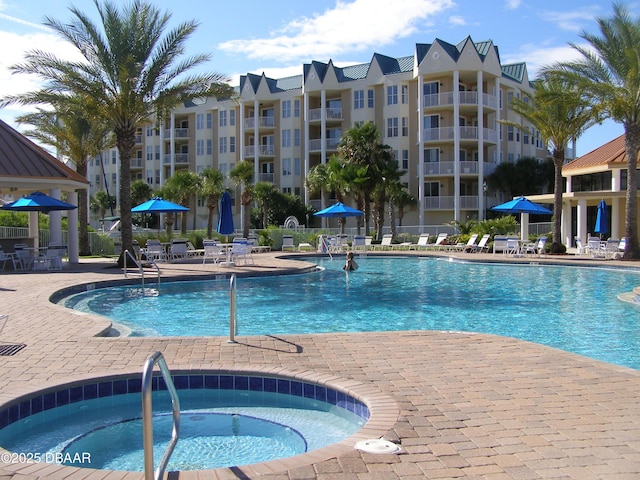 view of swimming pool featuring a hot tub