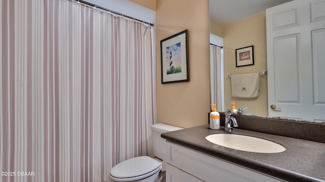 bathroom featuring toilet, a shower with shower curtain, and vanity