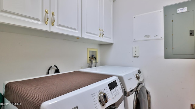 laundry room with electric panel, independent washer and dryer, and cabinets