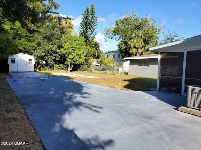 exterior space with a sunroom, a storage unit, and central AC unit