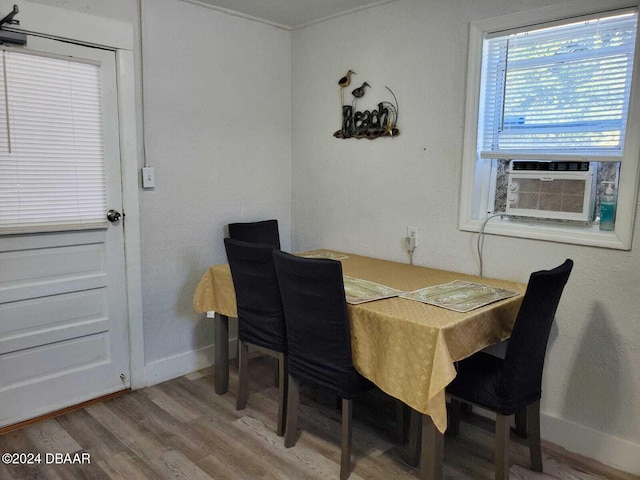 dining space with cooling unit and wood-type flooring