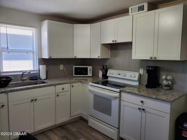 kitchen with white appliances, dark wood-type flooring, white cabinets, sink, and a textured ceiling