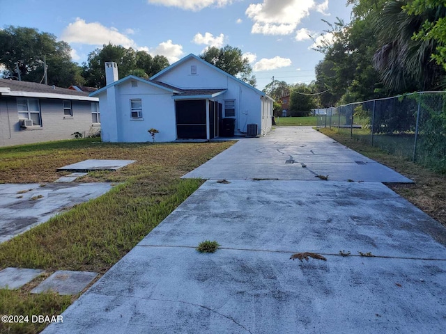 view of front of property with a front lawn, cooling unit, and central air condition unit