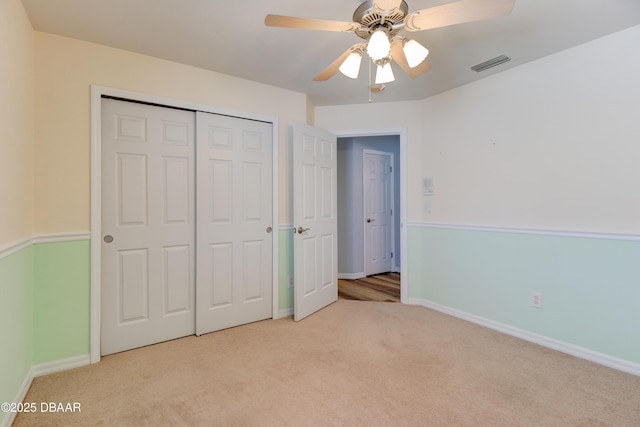 unfurnished bedroom with light carpet, a closet, visible vents, and baseboards