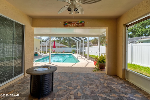 view of pool with central AC unit, a ceiling fan, glass enclosure, a patio area, and a fenced backyard