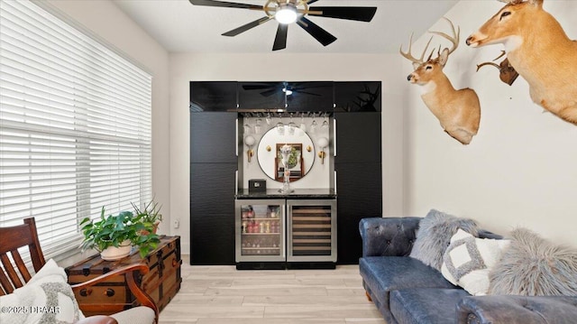 living room featuring wine cooler, ceiling fan, and light hardwood / wood-style flooring