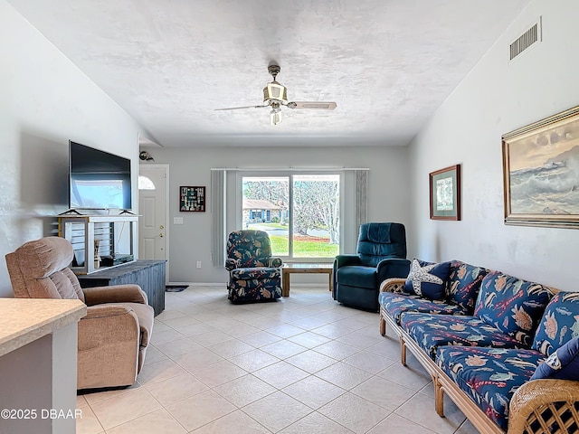 living room featuring ceiling fan, visible vents, and light tile patterned flooring