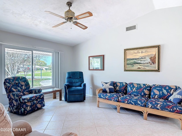 living area with lofted ceiling, ceiling fan, tile patterned flooring, visible vents, and baseboards