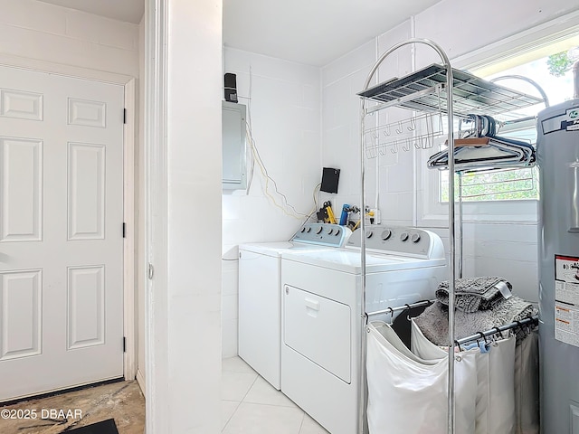 washroom featuring laundry area, electric water heater, tile walls, and washing machine and clothes dryer