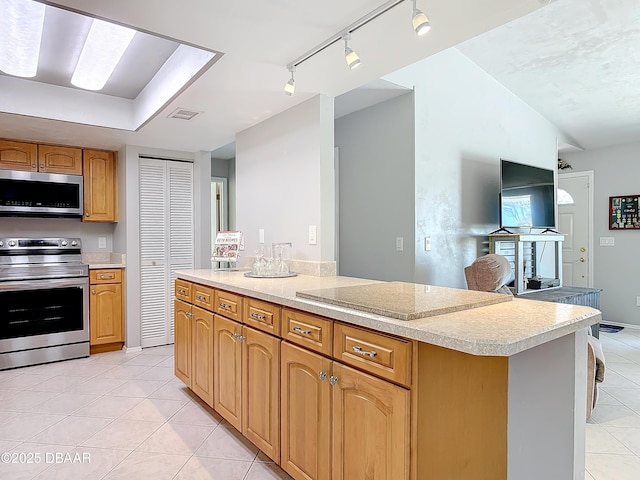 kitchen with light tile patterned floors, stainless steel appliances, light countertops, vaulted ceiling, and a peninsula