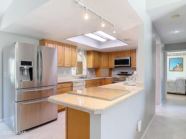 kitchen featuring appliances with stainless steel finishes, light countertops, a sink, and light tile patterned flooring