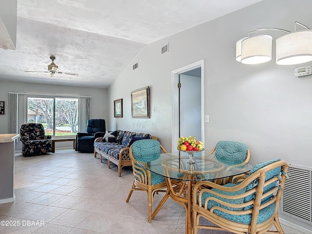 dining room with light tile patterned floors, visible vents, and vaulted ceiling