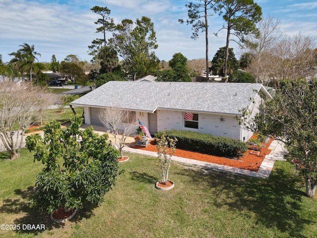 single story home with a garage, roof with shingles, brick siding, and a front lawn