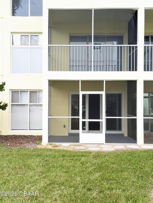 717 S Beach St Unit 102C, Daytona Beach, FL 32114 - rear view of property featuring stucco siding and a yard
