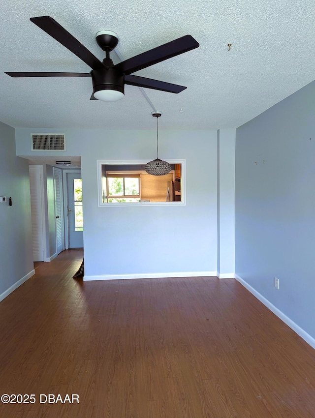 717 S Beach St Unit 102C, Daytona Beach, FL 32114 - unfurnished living room featuring a textured ceiling, a ceiling fan, and wood finished floors