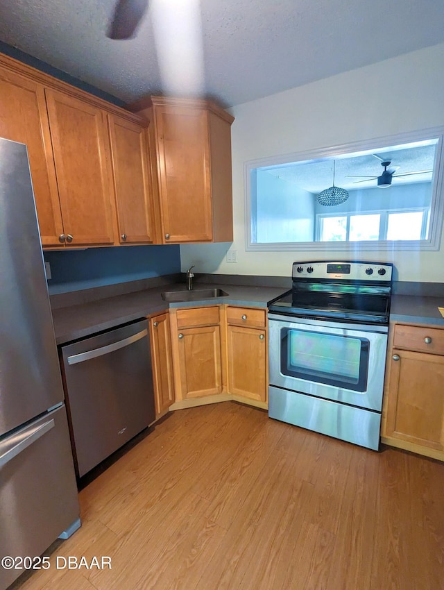 717 S Beach St Unit 102C, Daytona Beach, FL 32114 - kitchen featuring appliances with stainless steel finishes, light wood finished floors, and dark countertops