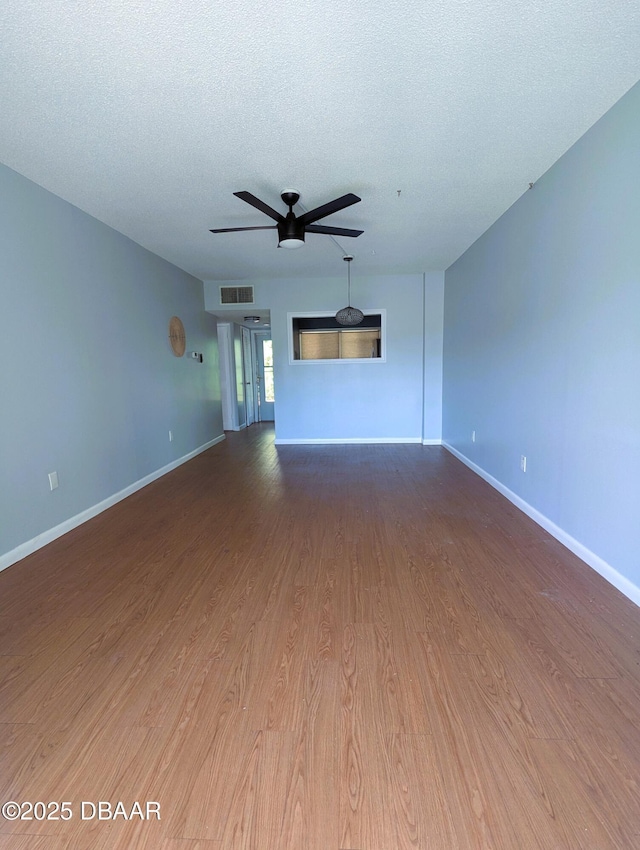 717 S Beach St Unit 102C, Daytona Beach, FL 32114 - unfurnished living room featuring ceiling fan, wood finished floors, and a textured ceiling