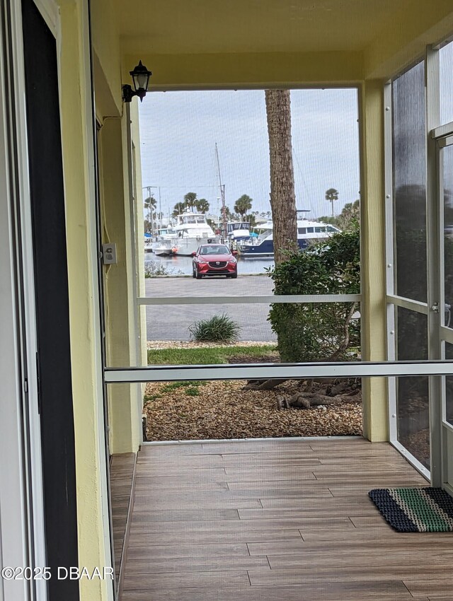717 S Beach St Unit 102C, Daytona Beach, FL 32114 - unfurnished sunroom with wood finished floors, a water view, and plenty of natural light