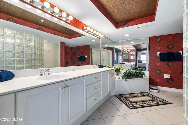 full bath featuring tile patterned flooring, a sink, visible vents, a tray ceiling, and wallpapered walls