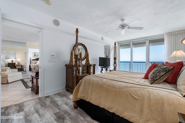 bedroom featuring access to exterior, ceiling fan, baseboards, and light wood-style floors