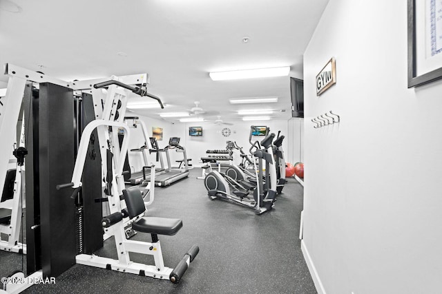 workout area featuring a ceiling fan and baseboards