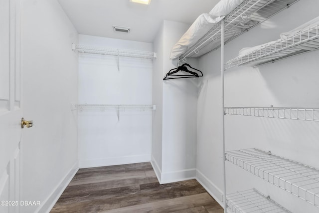 walk in closet with visible vents and dark wood finished floors