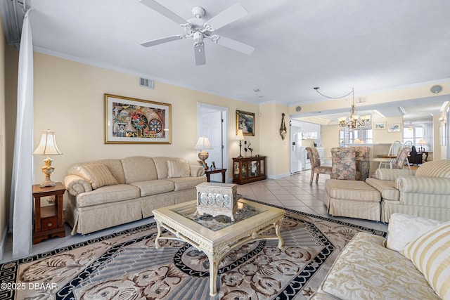 living area featuring light tile patterned floors, baseboards, visible vents, crown molding, and ceiling fan with notable chandelier