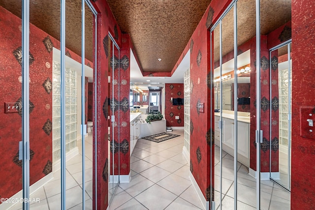 hall with baseboards and light tile patterned floors