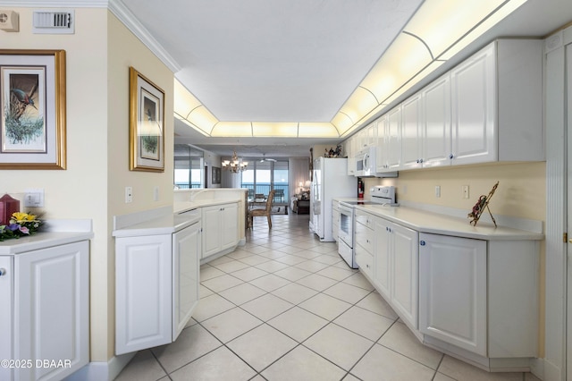 kitchen with white appliances, visible vents, white cabinets, light countertops, and an inviting chandelier